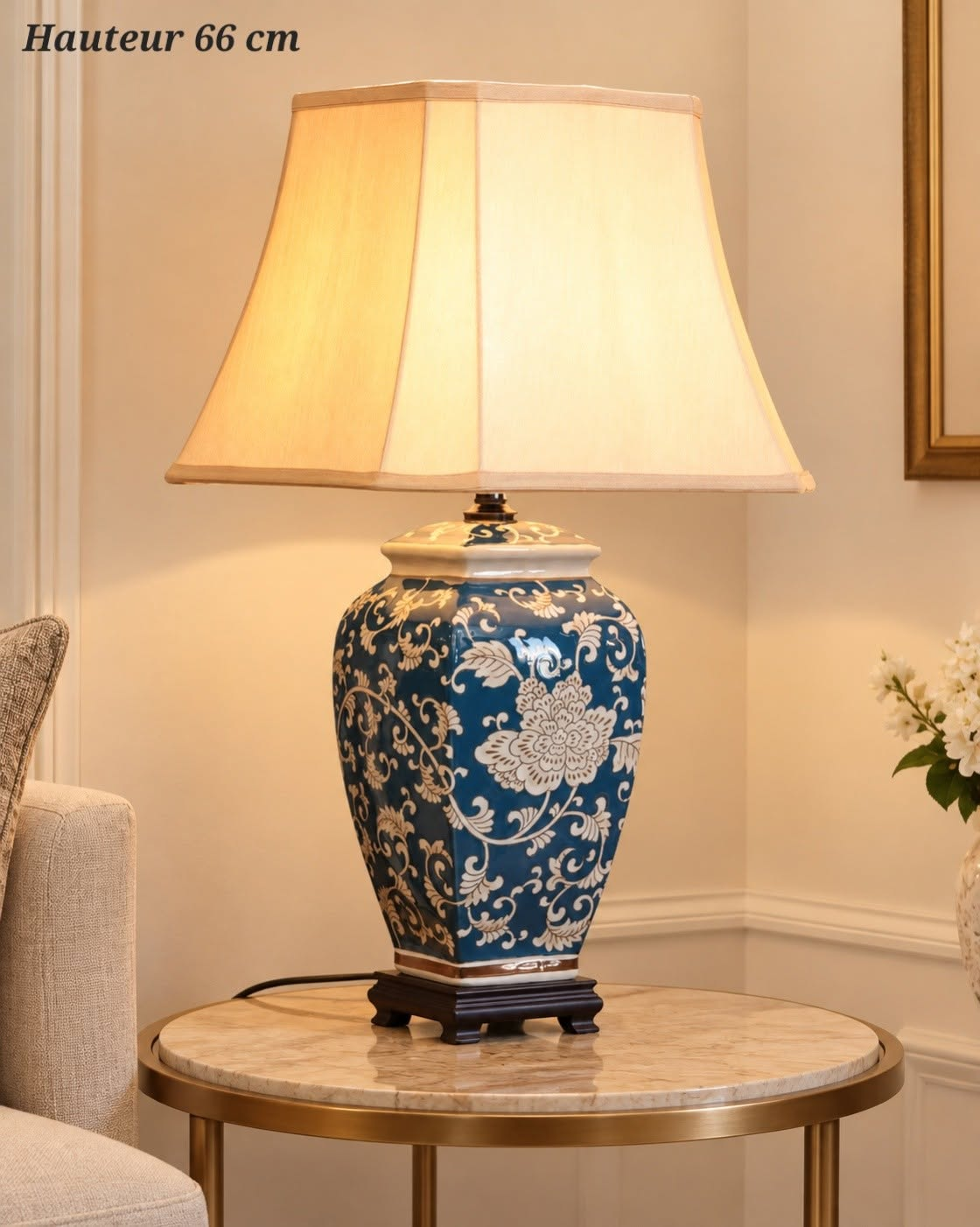 Lampe à poser de 66 cm avec pied bleu à motifs floraux clairs, abat-jour crème et socle foncé.